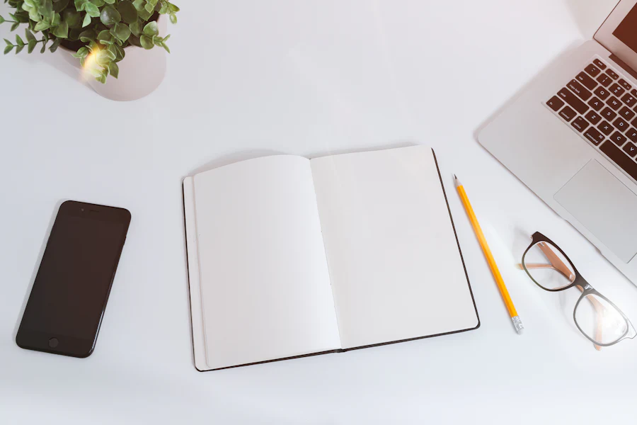 Open notebook next to a laptop on a desk